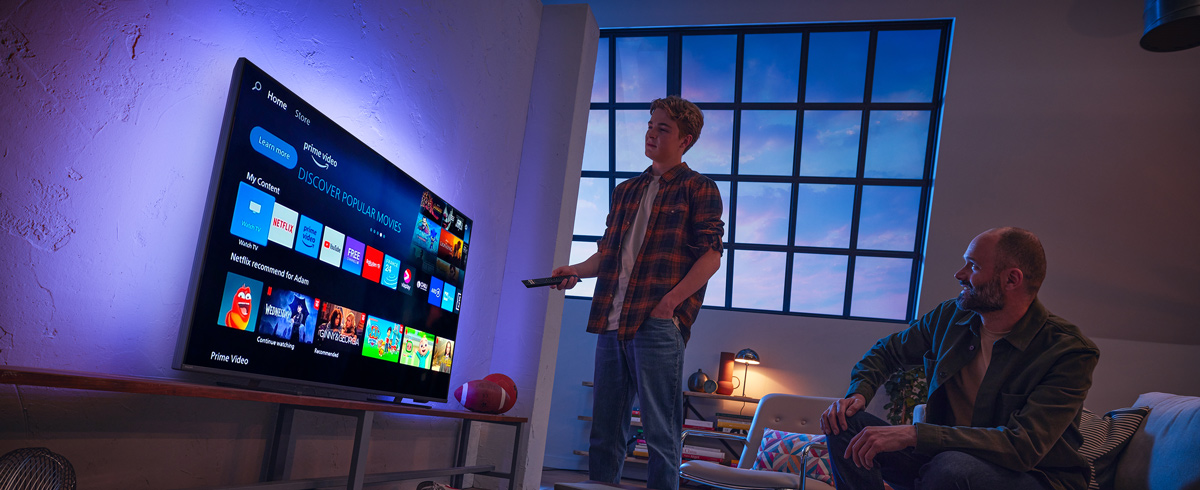 Mies valitsemassa sovellusta Philips Smart TV:st&auml;